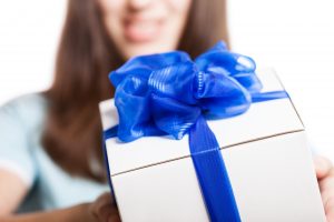 Smiling woman hand holding gift or present box