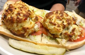 Two crab cakes in an open-faced sandwich.