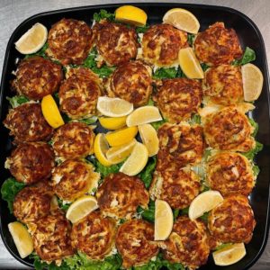 box hill crab cakes on a platter with lemon slices